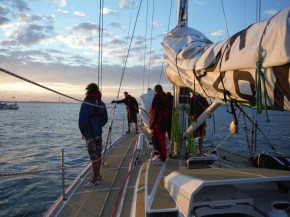 Spotting anchor (that is what he is pointing at, not a whale or mermaid. Big guys readying to bring it on deck.