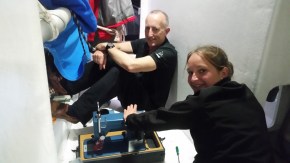 Nigel and Deb with sewing machine in the hallway (quite narrow if you see Nigel's feet propped. 