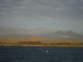 Coastal land with mountains in the background